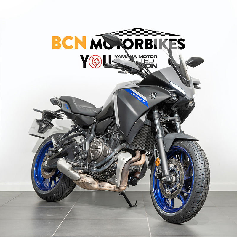 Yamaha Tracer 7 del 2021 color grey, COLOCADA EN DIAGONAL sobre fondo blanco con el logo de BCN MOTORBIKES detrás.