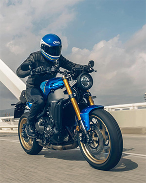 Yamaha XSR900 blue con poloto llevando casco arai blue, foto en el puente del puerto de barcelona